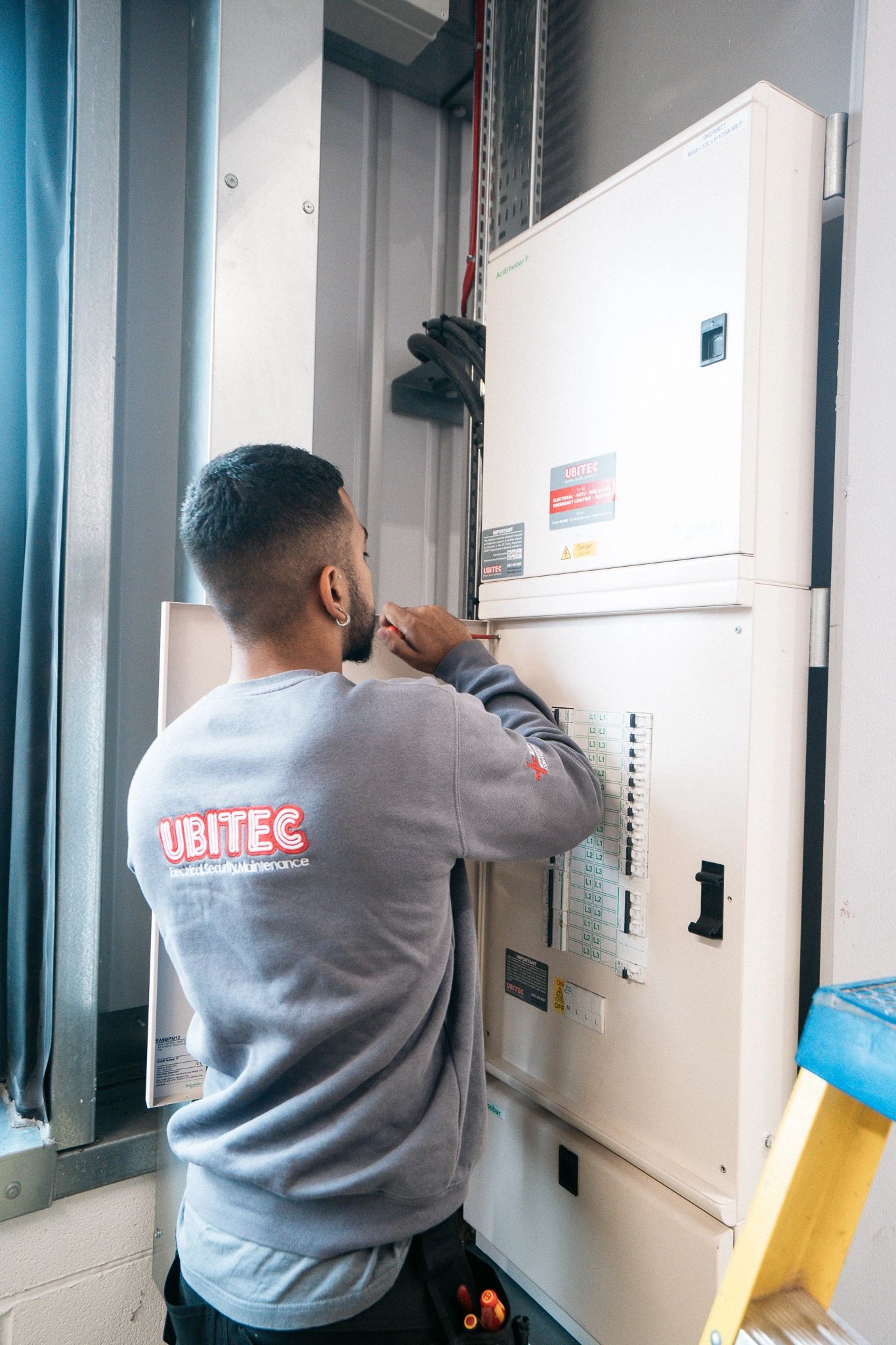 A Ubitec electrician inspecting a fuse board.