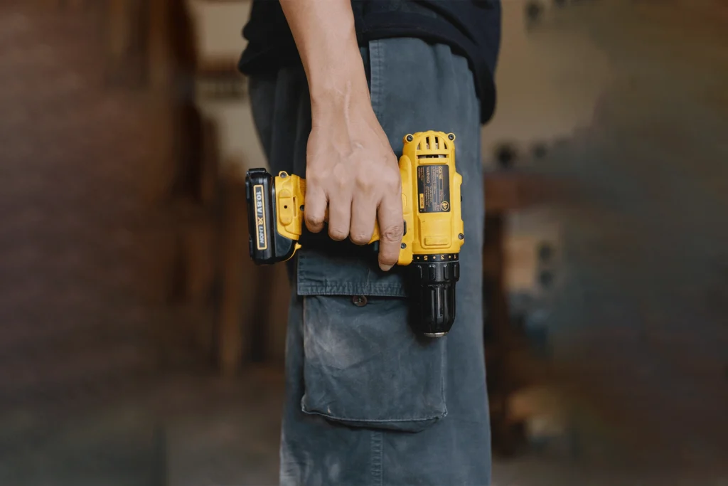 A person holding a drill.